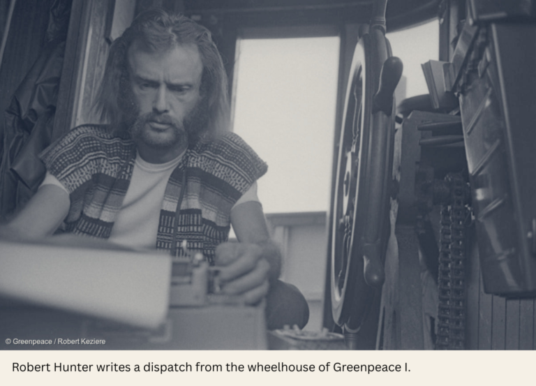 Bob Hunter sits at a typewriter in the Greenpeace pilot house.