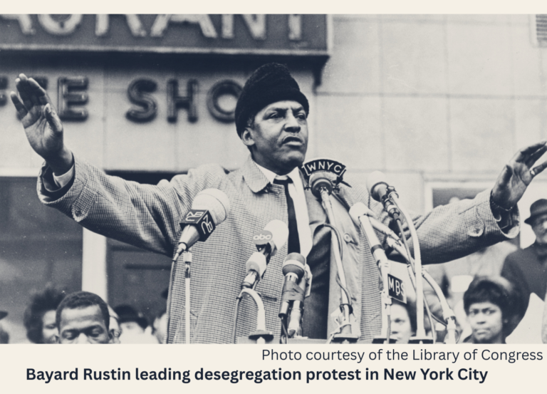 Bayard Rustin stands at the microphone to address people protesting New York school segregation.